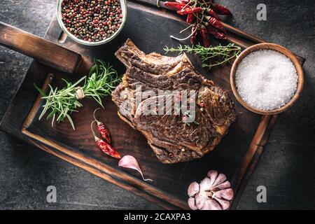 Gegrilltes Rindersteak mit Gewürzen Kräuter Salz Pfeffer und Knoblauch Auf Holzschneidebrett Stockfoto