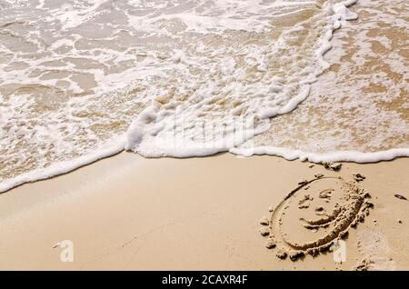 Ein Smiley-Gesicht wird in den Sand am Strand gezogen, als die Wellen am 24. Dezember 2012 in Dauphin Island, Alabama, einstürzen. (Foto von Carmen K. Sisson/Cloudybright) Stockfoto