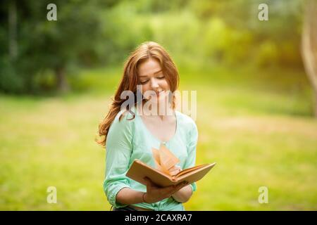 Schöne Verträumte Redhead Girl Lesebuch Im Park, Genießen Zeit Im Freien Stockfoto