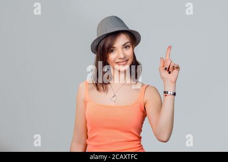 Nach oben zeigt. Closeup Portrait intelligente hübsche junge Frau Finger nach oben zeigen die Kopie Raum, isoliert, grauen Hintergrund. Positive emotion Gesichtsbehandlung Express Stockfoto