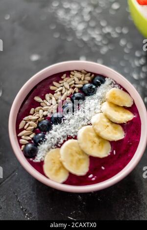 Nahaufnahme Draufsicht von einem leckeren Genuss am table.dessert mit Samen, Bananen, Blaubeeren und Kokosflocken Stockfoto