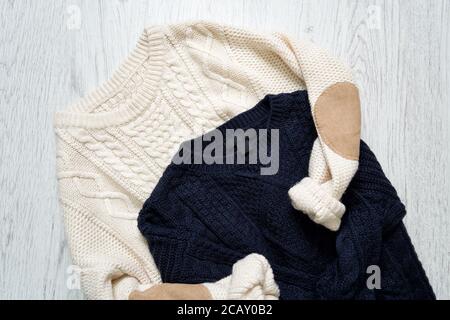 Zwei warme Strickpullover auf Holzgrund. Modisches Konzept Stockfoto