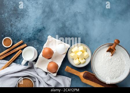 Zutaten zum Backen und Küchenutensilien auf blauem Hintergrund. Kopieplatz für Text oder Design in der Draufsicht Stockfoto