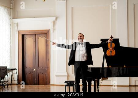 Professionelle kaukasische männliche Geiger nach dem Auftritt auf einer Bühne. Mann machte tolle Leistung, stehen auf einer Bühne mit Violine nach dem Konzert Stockfoto