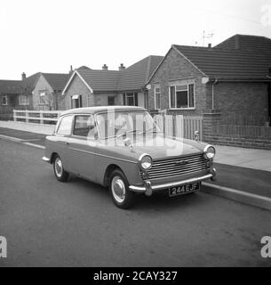 1960, historisch, ein Austin A40 Farina Auto geparkt in einer Straße von Bungalows, England, Großbritannien. Ein kleines, sparendes Auto, hergestellt von der britischen Motor Coporation (BMC) wurde es den Namen Austin A40 Farina, was das neue Design des italienischen 'Battista Farina Pinin Farina Turin Studio widerspiegelt. Das hier gezeigte Auto ist die Mark 1 Limousine, die zwischen 1958 und 1961 gebaut wurde. Stockfoto