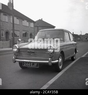 1960, historisch, ein Austin A40 Farina Auto geparkt in einer Straße auf einem neuen Wohngebiet, England, Großbritannien. Ein kleines, sparendes Auto, hergestellt von der britischen Motor Coporation (BMC) wurde es den Namen Austin A40 Farina, was das neue Design des italienischen 'Battista Farina Pinin Farina Turin Studio widerspiegelt. Das hier gezeigte Auto ist die Mark 1 Limousine, die zwischen 1958 und 1961 gebaut wurde. Stockfoto