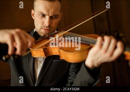 Nahaufnahme Porträt des jungen kaukasischen Mann spielen Geige, professionelle Geiger führen Musik, Üben Stockfoto