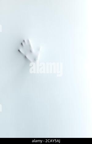 Silhouette der Handfläche des Mannes.Geste, Körpersprache. Simbol, hallo, hallo, Gruß, Handprint der verrückten Frau.Horror Mann Gesicht. Hand hinter dem Milchglas Stockfoto