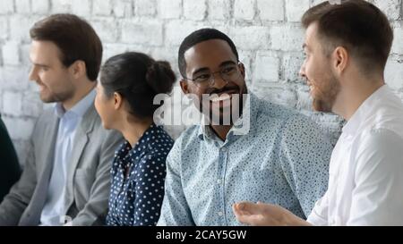 Nahaufnahme lächelnder afroamerikanischer Geschäftsmann im Chat, wartet auf ein Interview Stockfoto