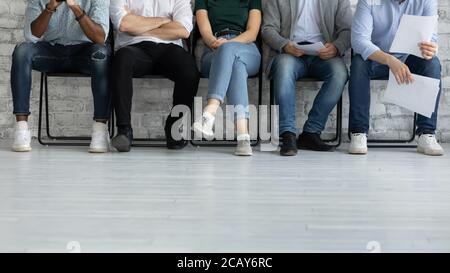 Beschnittenes Bild Beine von verschiedenen Kandidaten warten auf Vorstellungsgespräch Stockfoto