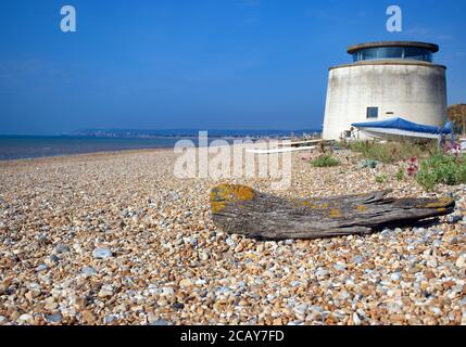 Ein Blick auf Martello Tower No. 55 Blick nach Westen entlang des Kiesstrandes in Richtung Eastbourne von Normans Bay, Sussex, England, Großbritannien. Stockfoto