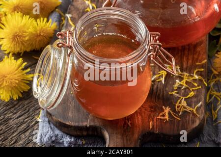 Ein Glas Löwenzahn Honig mit frischen Blumen Stockfoto