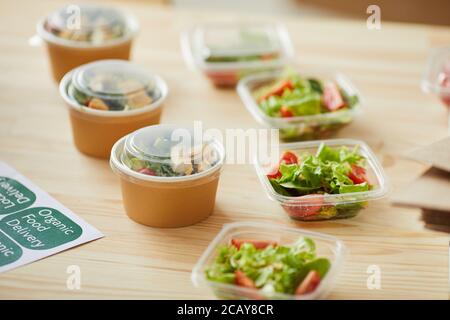 Hintergrundbild von gesunden Lebensmitteln Portionen bereit für die Verpackung auf Holztisch in kleinen Lebensmittel-Lieferservice, kopieren Platz Stockfoto