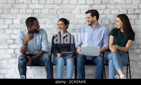 Junge verschiedene Kandidaten lachen, plaudern, warten auf Vorstellungsgespräch Stockfoto