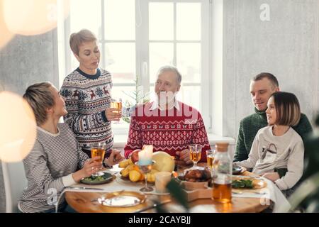 Der alte Mann hat seine Töchter und ihre Familien in den Winterferien versammelt Stockfoto