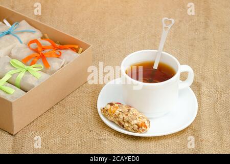 Tasse Tee, eine Bar mit Müsli und Schachteln mit Bars. Sacktuch Stockfoto