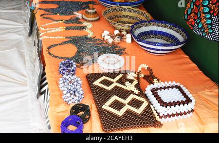 Ruanda handgefertigte Juwelen und Ornamente auf einem orangen Tisch Tuch bei einer Ausstellung in Rwamagana Stockfoto