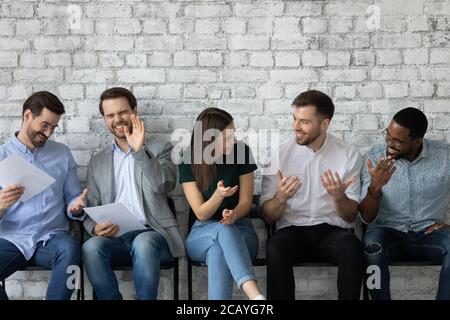 Überglücklich verschiedene Kandidaten chatten, lachen, warten auf Interview Stockfoto