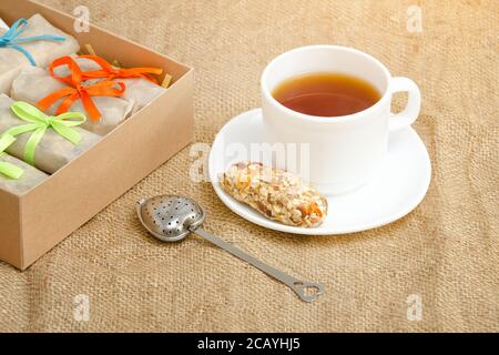 Tasse Tee, eine Bar mit Müsli und Schachteln mit Bars. Sacktuch Stockfoto