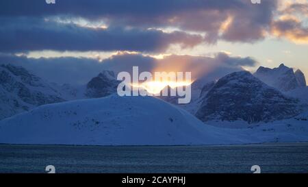 Schneebedeckte Berge nach Sonnenuntergang in der Nähe von Fredvang auf den Lofoten-Inseln von Norwegen. Stockfoto