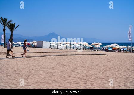 Ein Paar mit Gesichtsmasken geht zum Strand von Playa San Juan Alicante, Spanien, Europa, Juli 2020 Stockfoto