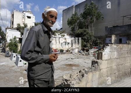 Beirut, Beirut, Libanon. August 2020. Libanesischer Mann inspiziert am 9. August 2020 das beschädigte Gebäude in der Nähe der Sprengstelle im Hafengebiet von Beirut, Libanon, nach einer kolossalen Explosion, die Tage zuvor aufgrund eines riesigen Ammoniumnitratstapels stattfand, der jahrelang in einem Hafenlager verschmachtet hatte. Die riesige chemische Explosion, die den Hafen von Beirut heimgesucht hat, große Teile der libanesischen Hauptstadt zerstört und über 150 Menschenleben gefordert hat, hinterließ einen 43 Meter (141 Fuß) tiefen Krater, sagte ein Sicherheitsbeamter. Der Knall Dienstag, der im ganzen Land und bis zur Insel Zypern gefühlt wurde, war Stockfoto