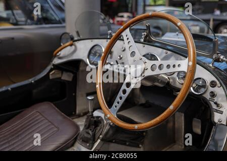 Ausgewählte Fokus auf einzigartige dekoriert glänzend und Holz Lenkrad und Metallic-Armaturenbrett im Vintage-Klassiker alten Sportwagen. Stockfoto