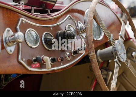 Vintage Detail von Spur, Schalter, Knopf, Meter und Holz Lenkrad auf Holz-Bedienfeld Armaturenbrett im alten antiken Cabriolet Auto. Stockfoto