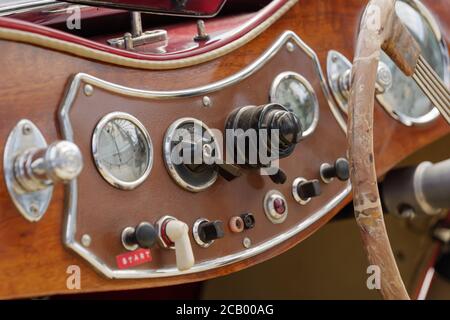 Vintage Detail von Spur, Schalter, Knopf, Meter und Holz Lenkrad auf Holz-Bedienfeld Armaturenbrett im alten antiken Cabriolet Auto. Stockfoto