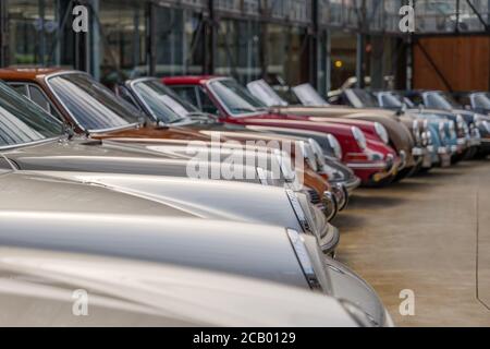 Ausgewählte Fokussierung auf Scheinwerfer und Motorhaube von Porsche Luxussportwagen der Gruppe bei Classic Remise in Düsseldorf. Reihe von Parkplätzen Luxus Autos Stockfoto