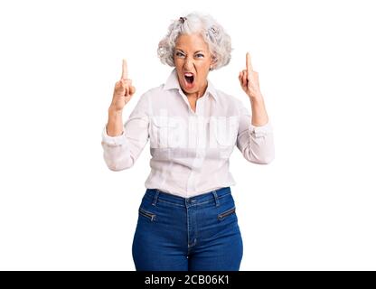 Ältere grauhaarige Frau trägt Freizeitkleidung schreien mit verrückten Ausdruck Rock-Symbol mit Händen nach oben. Musik-Star. Heavy-Konzept. Stockfoto