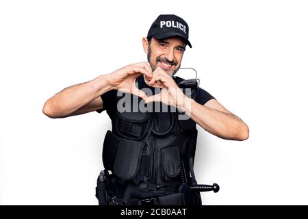 Mittlerer Alter Polizist trägt Polizei Uniform und kugelsichere Weste über weißem Hintergrund lächelnd in der Liebe tun Herz Symbol Form mit Händen. Romantisch c Stockfoto