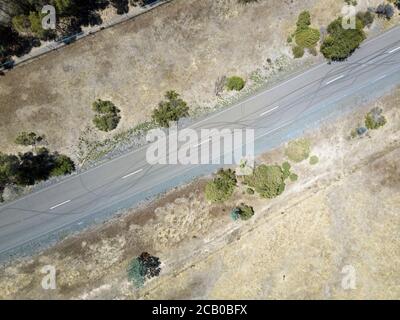 Autoabsperrmarkierung Luftaufnahme auf asphaltierten Straßen mit Grasfeldern und Zaun, Victoria, Australien. Stockfoto