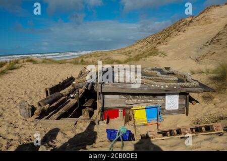 Gemütliche Holzhütte aus Müll in den Dünen eines wilden Atlantikstrandes am Lacanau Ocean, Gironde, Frankreich. Stockfoto