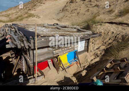 Gemütliche Holzhütte aus Müll in den Dünen eines wilden Atlantikstrandes am Lacanau Ocean, Gironde, Frankreich. Stockfoto