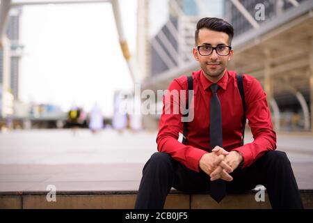 Junger hübscher persischer Geschäftsmann, der die Stadt erkundet Stockfoto