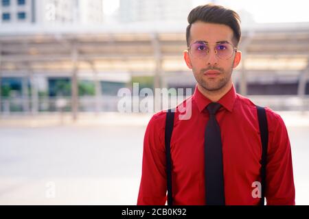 Junger hübscher persischer Geschäftsmann, der die Stadt erkundet Stockfoto