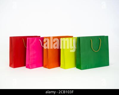 Bunte Einkaufstasche isoliert auf weißem Hintergrund. Reihe von mehrfarbigen, grün, hellgrün, orange, rosa und rote Farbe leere Papiertüten. Stockfoto