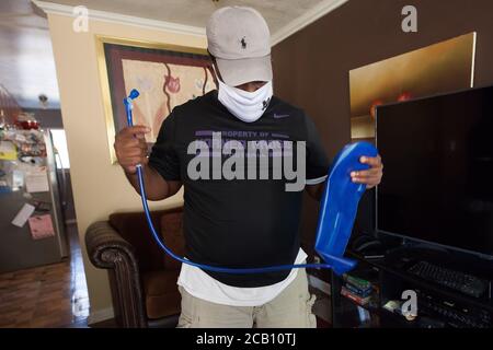 Ft Worth, TX, USA. August 2020. 8. August 2020: Leon Reed, Jr, hält seinen Wasserrucksack hoch, den er mit sich bringen wird, als er sich auf einen 200 Meilen langen Spaziergang von Ft Worth nach Austin, TX, aufmacht, um einen Brief zu überbringen und seine Gedanken zur Polizeireform mit Gov zu besprechen. Greg Abbott. Da er nicht sicher ist, wann er ankommen wird, hat er noch kein Treffen mit dem Gouverneur eingerichtet. Abbott, und er hofft, dass der Gouverneur ihn sehen wird. Leon ist seit 16 Jahren Strafverteidiger in Ft Worth und hofft, dass seine Ideen zu Veränderungen führen werden. Der Name seines Spaziergangs heißt Walk for Reform. (Bild: © Leslie Spurloc Stockfoto