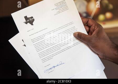 Ft Worth, TX, USA. August 2020. August 2020: Leon Reed, Jr, hält einen Brief, den er den Bürgermeistern der kleinen Städte geben wird, durch die er gehen wird, während er sich auf einem 200 Meilen langen Spaziergang von Ft Worth nach Austin, TX, einschiffen wird, um einen Brief zu überbringen und seine Gedanken zur Polizeireform mit Gov zu besprechen. Greg Abbott. Da er nicht sicher ist, wann er ankommen wird, hat er noch kein Treffen mit dem Gouverneur eingerichtet. Abbott, und er hofft, dass der Gouverneur ihn sehen wird. Leon ist seit 16 Jahren Strafverteidiger in Ft Worth und hofft, dass seine Ideen zu Veränderungen führen werden. Der Name seines Spaziergangs heißt Walk for Reform. Stockfoto