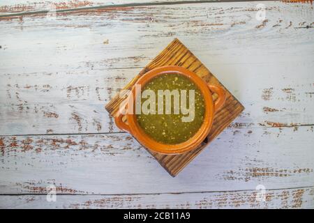 Blick von oben auf mexikanische grüne Sauce in Tontopf Stockfoto