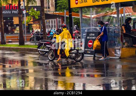 Ho-Chi-Minh-Stadt, Vietnam - 08 Aug 2020: Einheimische einkaufen im Emart Supermarkt, tragen medizinische Masken, Motorrad fahren im Regen und halten soziale d Stockfoto