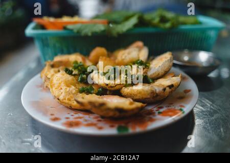 Vietnamesische Street Food "Banh kann" durch Reispulver mit Reismehl, Ei, Zwiebelblätter zu machen. Banh Can ist eine Portion vietnamesisches Street Food. Fotos von Lebensmitteln Stockfoto