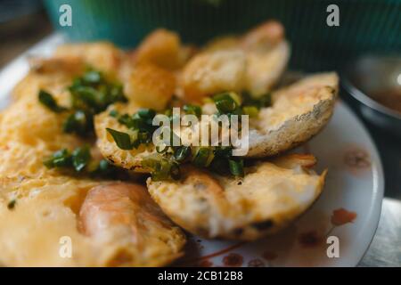 Vietnamesische Street Food "Banh kann" durch Reispulver mit Reismehl, Ei, Zwiebelblätter zu machen. Banh Can ist eine Portion vietnamesisches Street Food. Fotos von Lebensmitteln Stockfoto