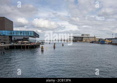 Kopenhagen, Dänemark - 2. August 2020: Das Schauspielhaus links mit dem Opernhaus im Hintergrund. Dies ist ein beeindruckendes, zweckgebautes Theater für Theaterstücke, plus elegantes Dining mit Hafen- und Stadtblick Stockfoto