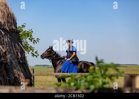 Traditioneller ungarischer Wrangler auf seinem Pferd in der Hortobagy Region, ländliches Ungarn. Stockfoto