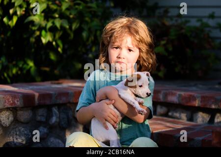 Traurige Kinder mit chihuahua Mischhund. Kind umarmt liebevoll seinen Hund. Stockfoto