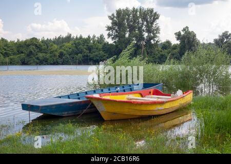 Alte hölzerne Fischerboote auf einem Teich. Traditionelle kleine Fischerboote am Flussufer im nördlichen Teil Serbiens. Stockfoto