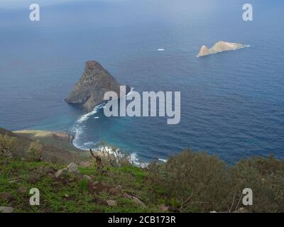 Blick auf Felsen im Meer El Draguillo mit grünen Hügeln und dramatischen blauen Himmel weißen Wolken in anaga Berg, teneriffa kanarische Insel spanien Stockfoto