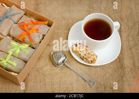 Tasse Tee, eine Bar mit Müsli und Schachteln mit Bars. Sacktuch Stockfoto